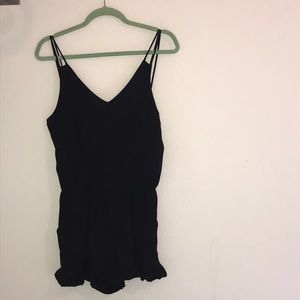 Black romper with ruffle shorts detail.